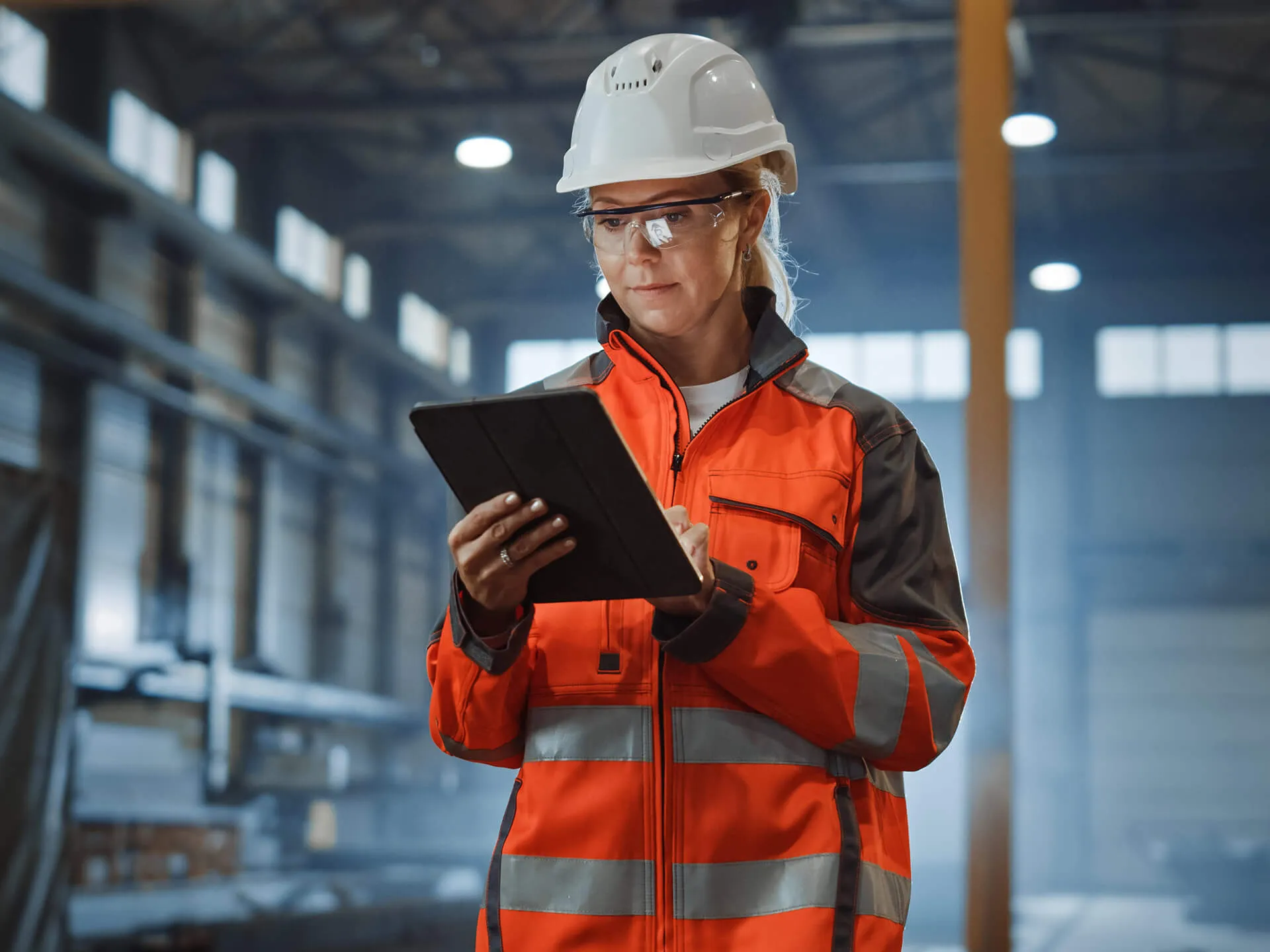 Professional industry engineer worker wearing safety uniform and hard hat, using tablet computer