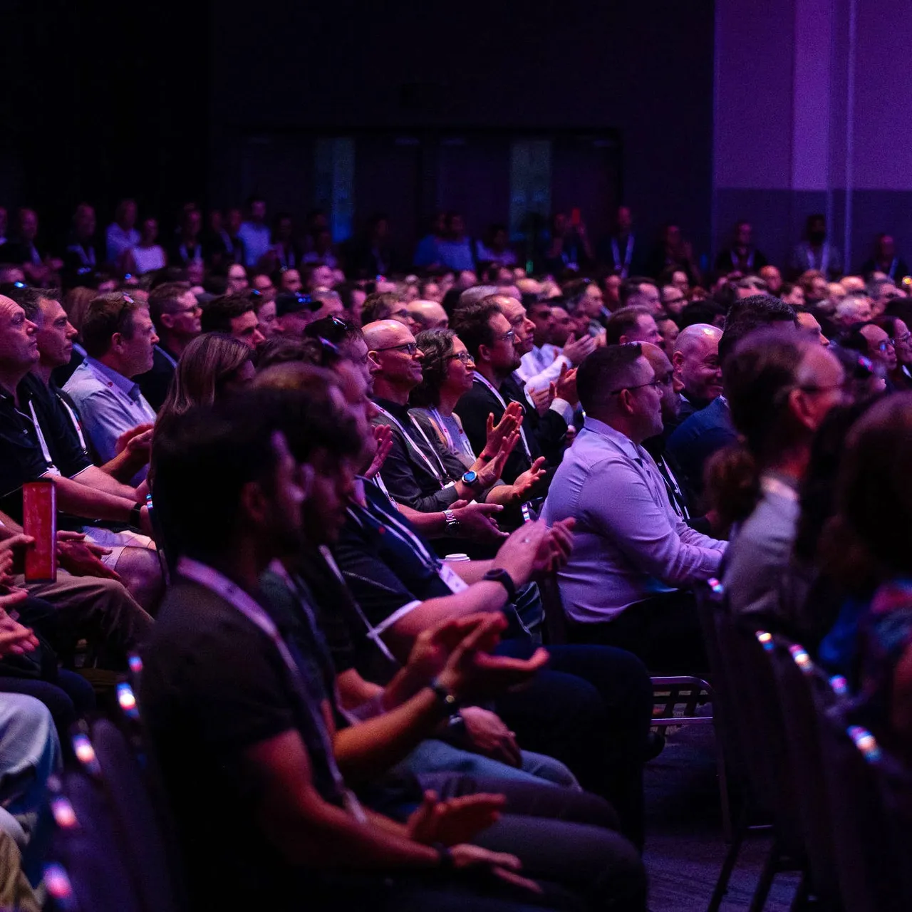 Audience seated in rows clapping and attentively watching a presentation at MAINSTREAM