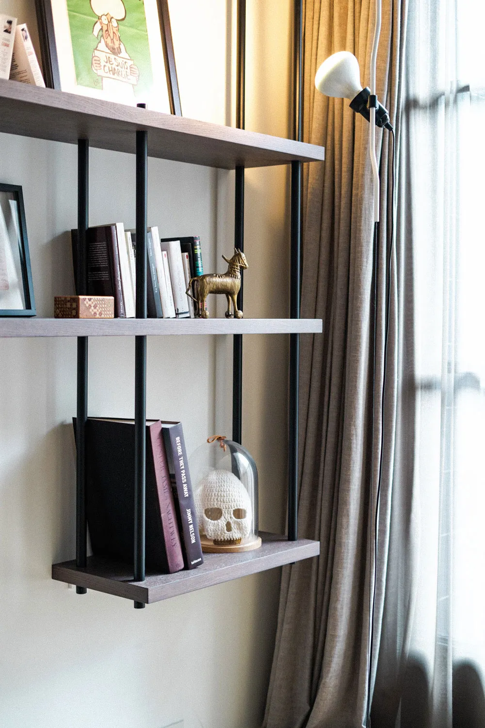 Architectural bookshelf design from the Modulo project by Studio Mosh, combining floating wooden shelves, dark metal framing, curated books, and artistic decor — sleek shelving for modern interiors.