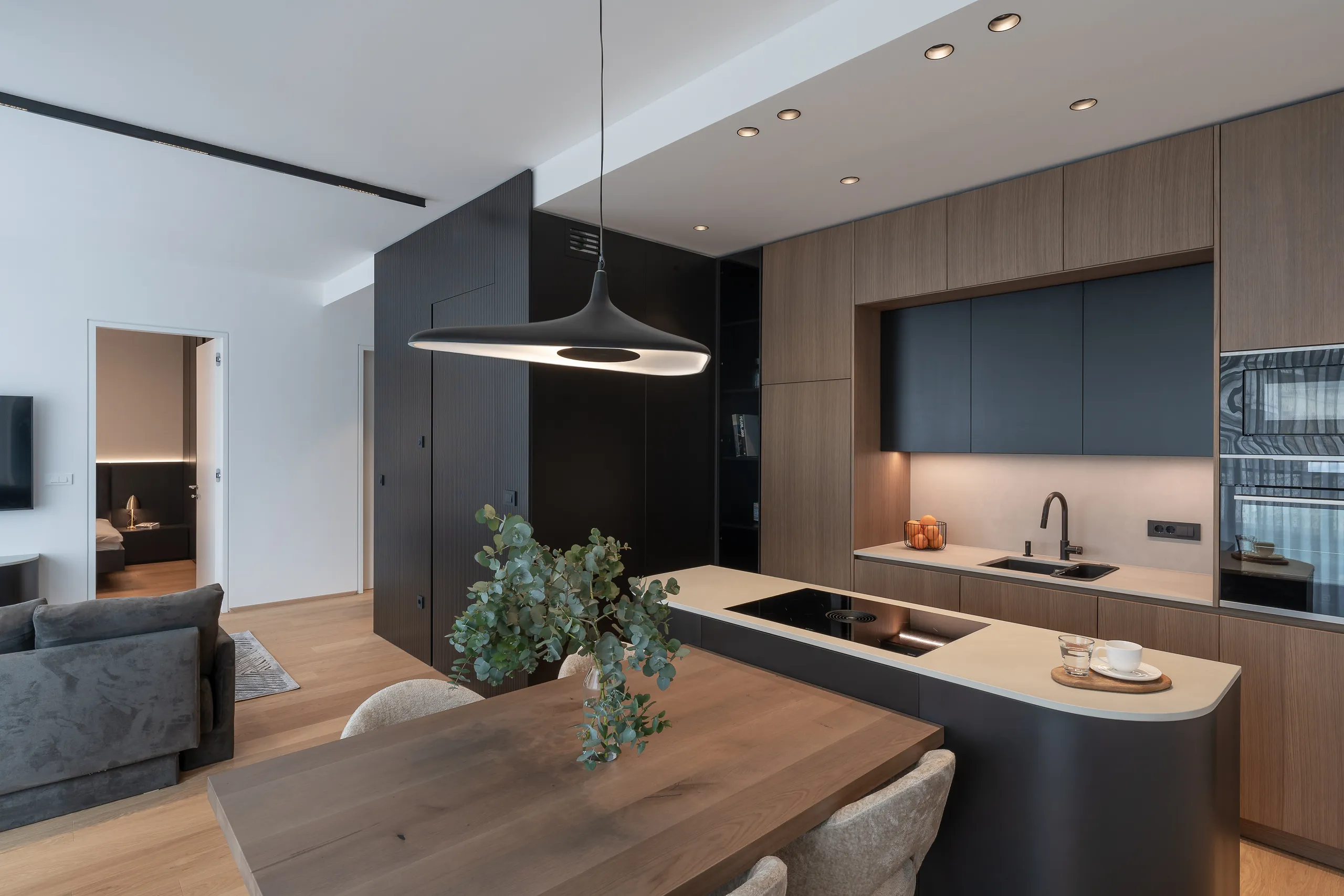 Scandinavian-inspired kitchen with clean lines, natural wood accents, and built-in black appliances – open living layout and modern finishes.