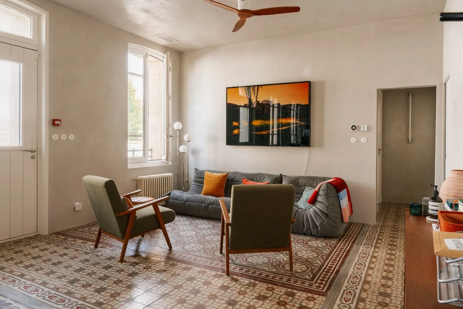 Modern rustic bedroom design in a luxury chalet by Studio Mosh, with wood-clad walls, upholstered headboard, layered bedding, and pendant lighting — elegant mountain retreat design with warm textures and soft lighting.