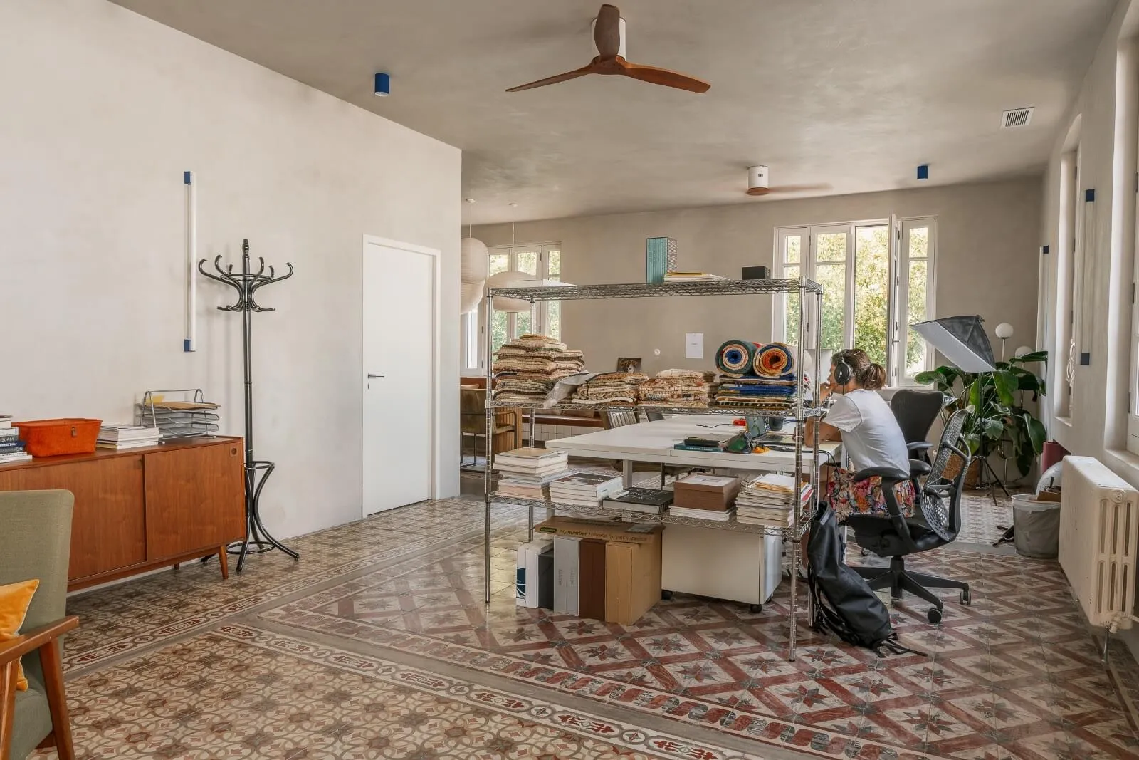 Sophisticated dining and kitchen space in a contemporary chalet interior by Studio Mosh, featuring pendant lighting, velvet dining chairs, a marble breakfast bar, and a floor-to-ceiling wine display — refined alpine living at its best.