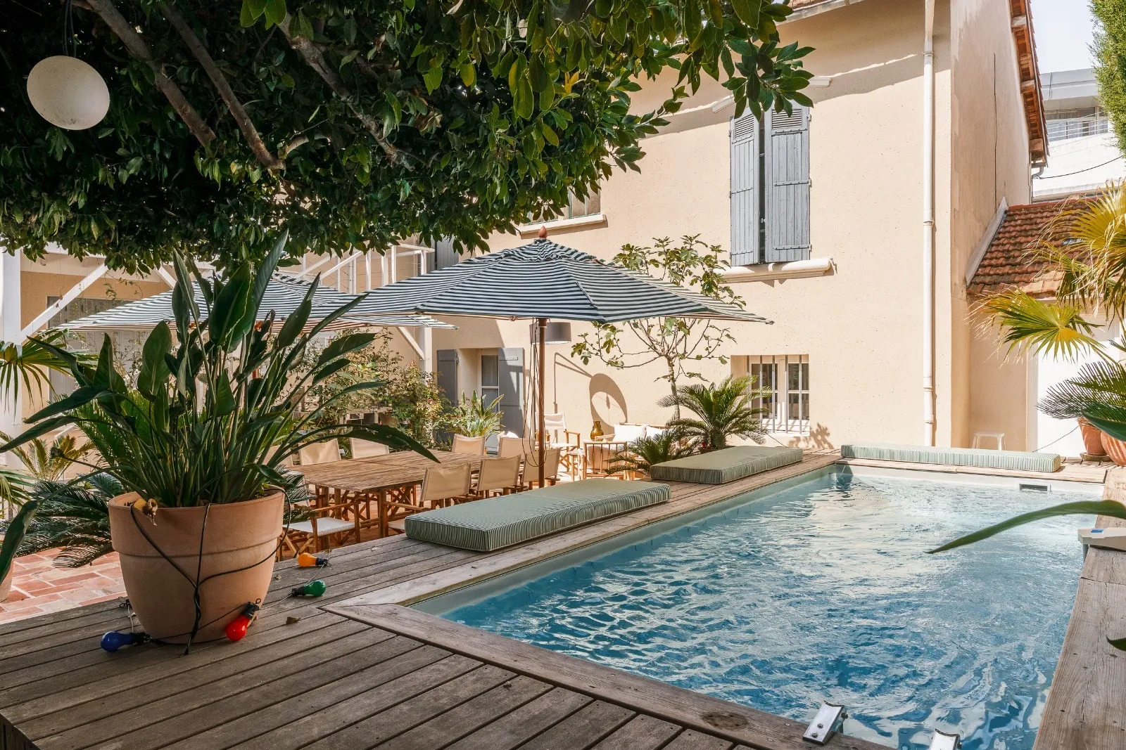 Open-plan living room and kitchen in a luxury mountain chalet by Studio Mosh, with exposed wooden beams, a marble island, rustic textures, and custom-built media wall — blending alpine comfort with modern interior design.