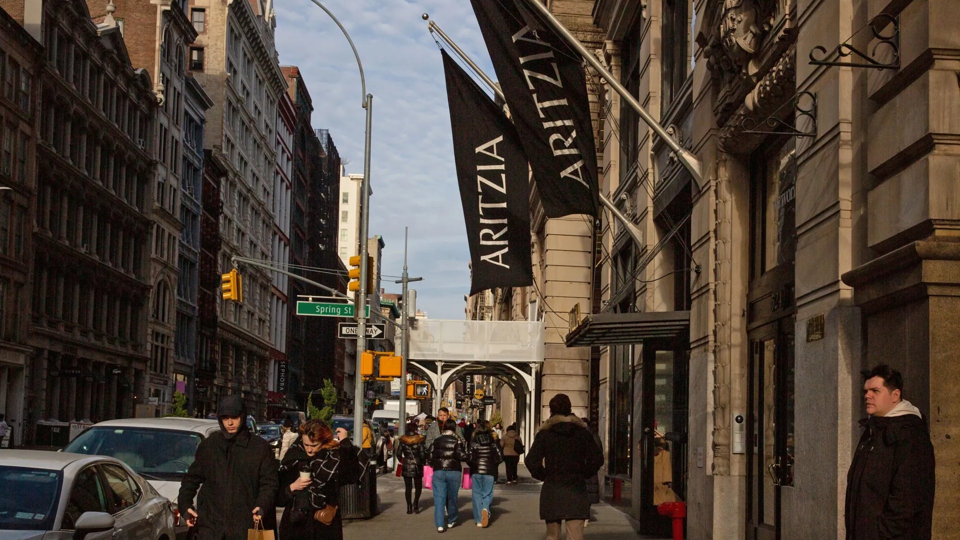Two black Aritzia flags hang over the sidewalk outside the SoHo boutique on Broadway at Spring Street in New York.
