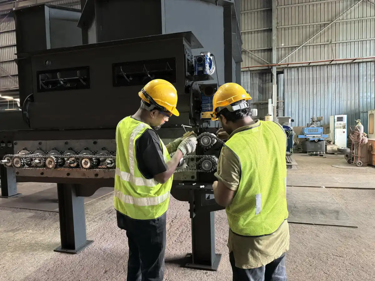 two people in hi-vis working on manufacturing a pyrolysis machine