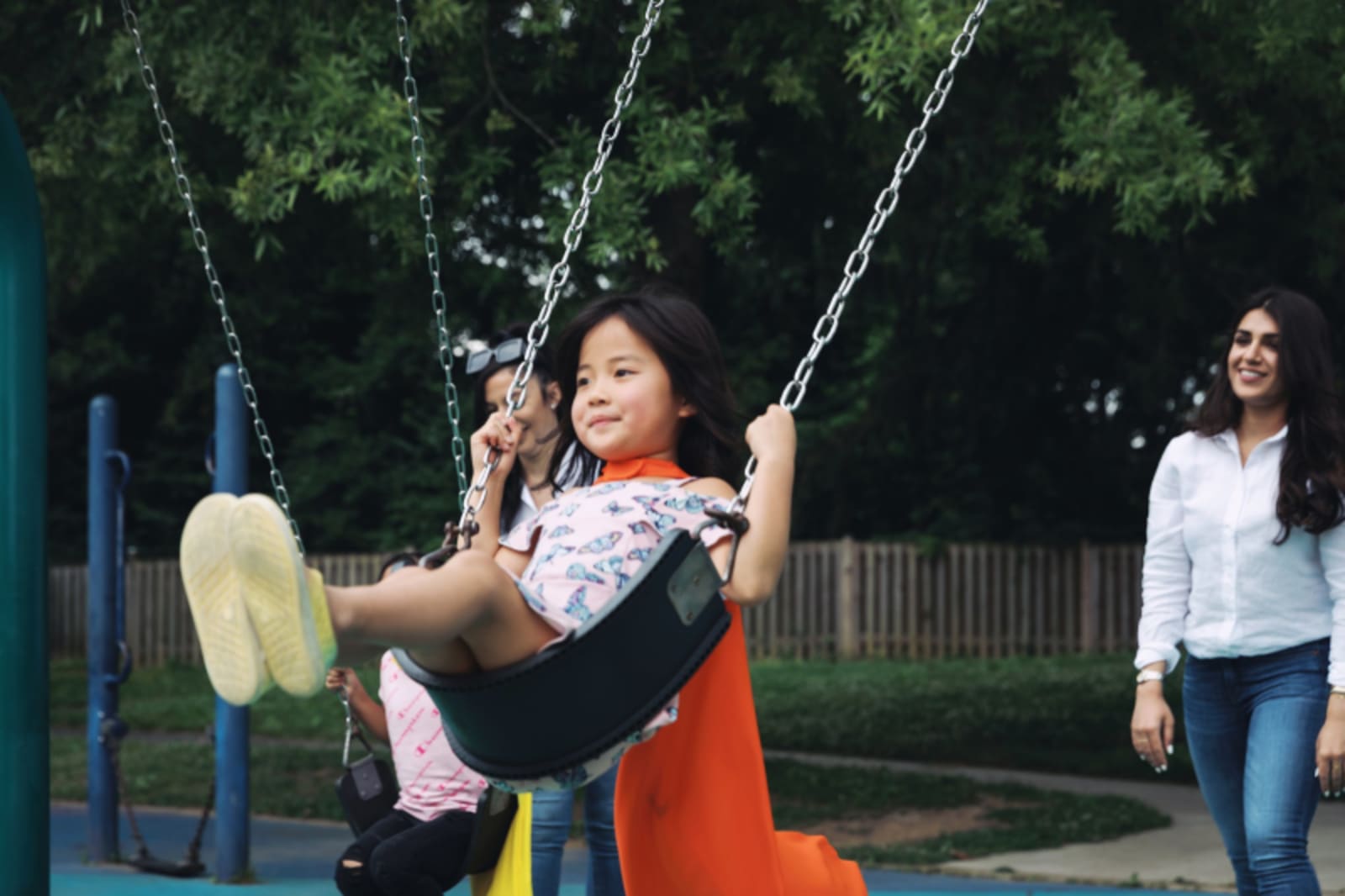 Child wearing clear Invisalign aligners and a cape at the park