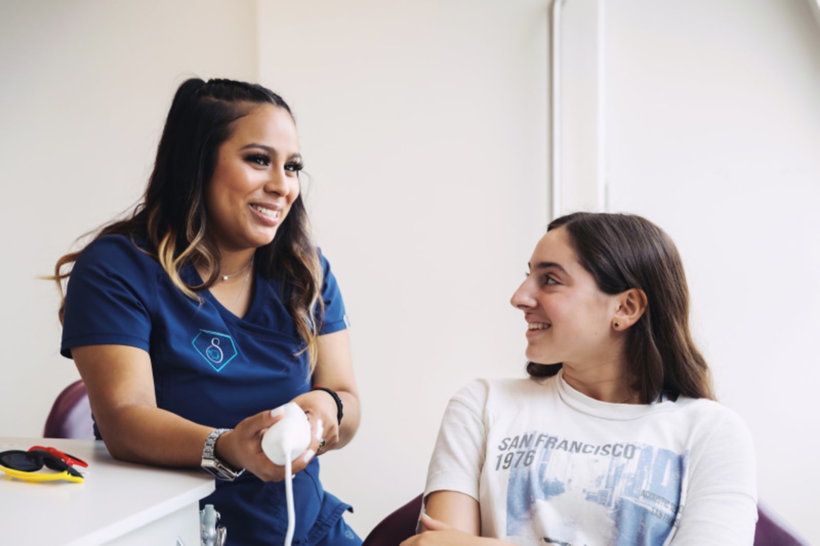 Pediatric dentist explaining treatment to young patient in clinical setting