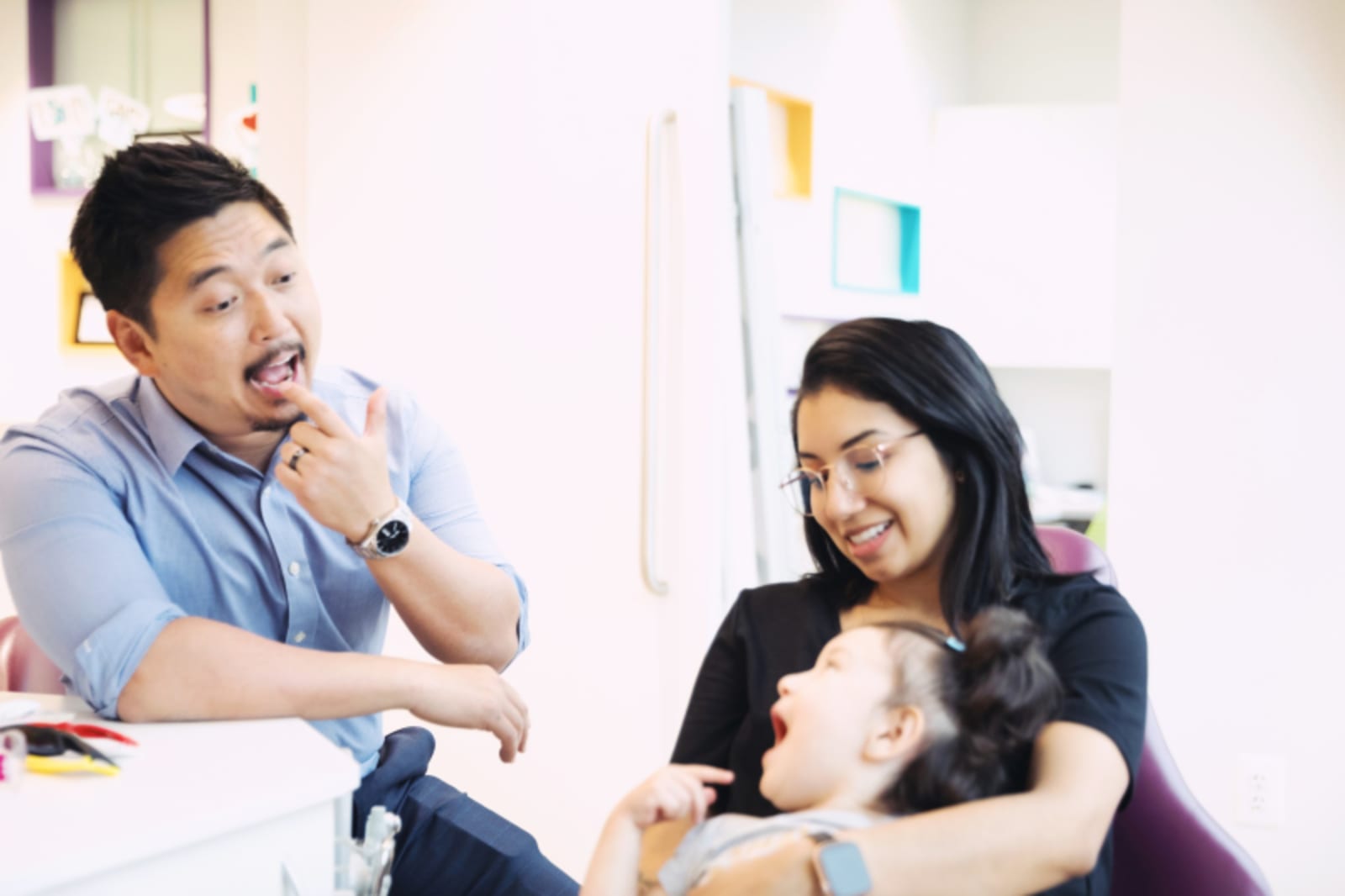 Male dentist discussing treatment with female patient in dental office