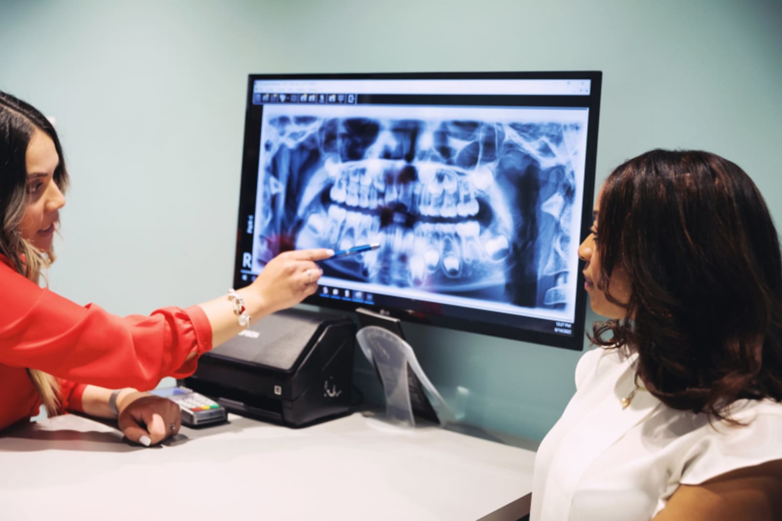 Dentist showing dental X-ray to young patient during exam at SuperKids Pediatric Dentistry.