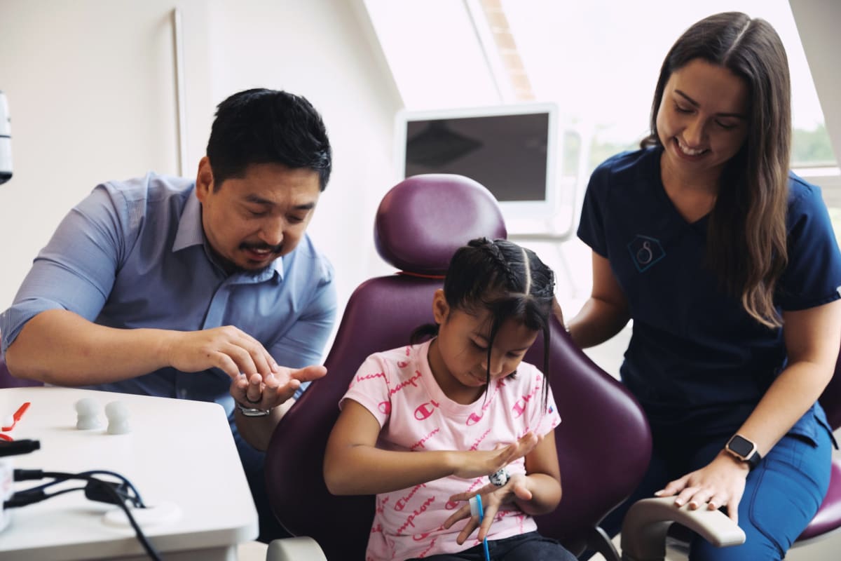 Pediatric dentist applying dental sealant to a young patient's tooth
