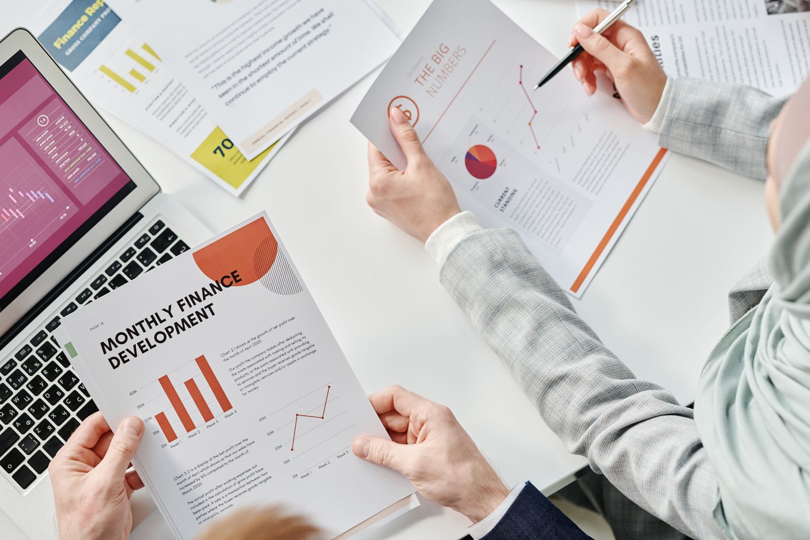 Colleagues reviewing financial reports and charts at a table