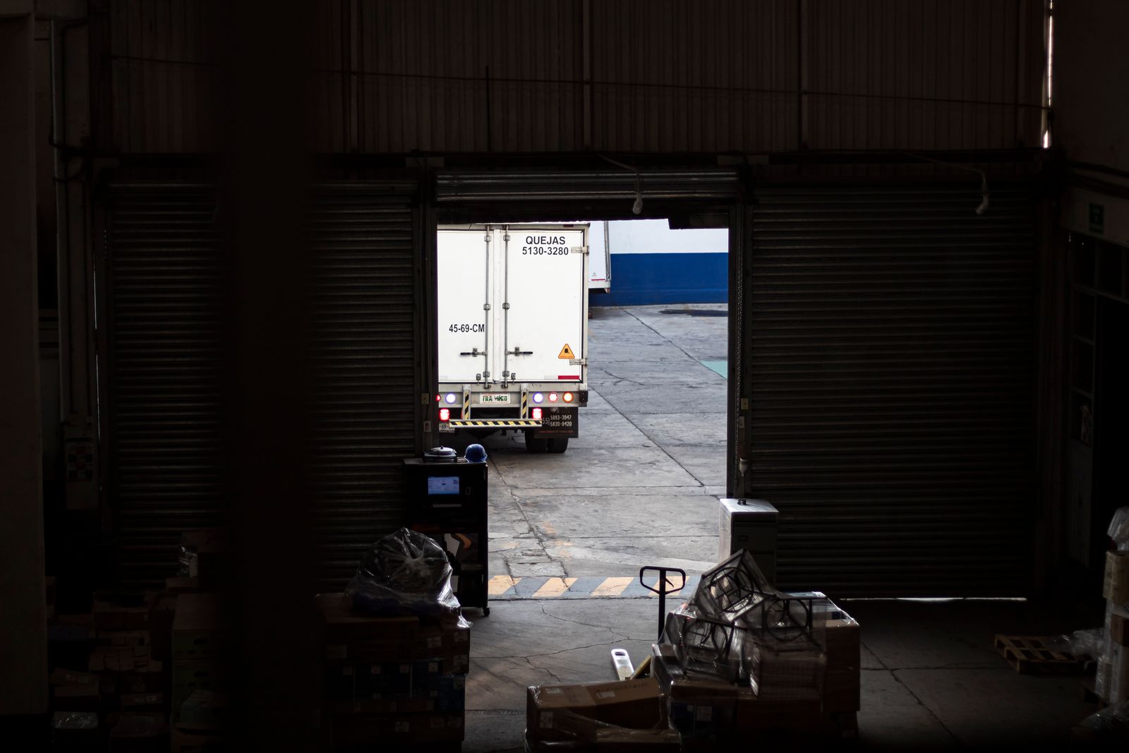 Delivery truck leaving a dim warehouse loading dock
