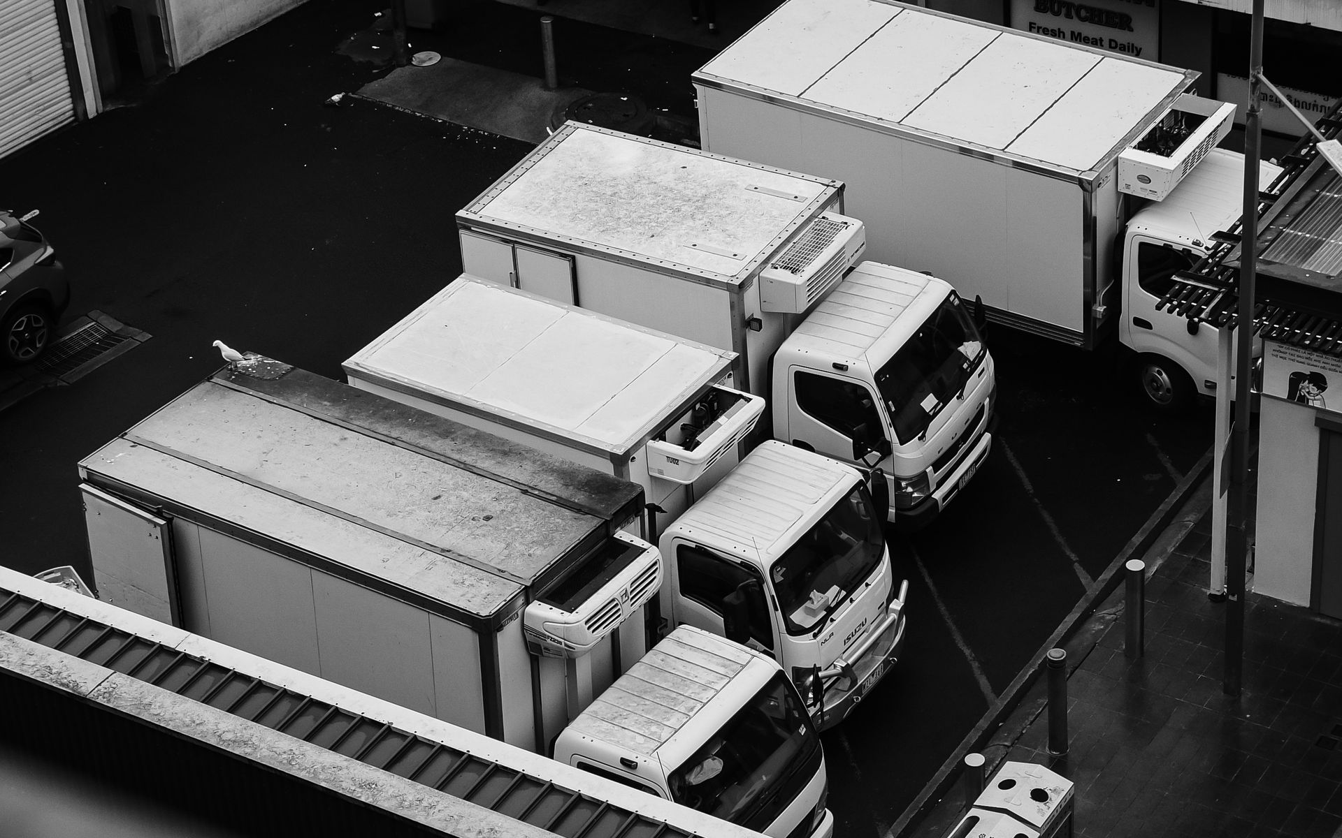 Black and white overhead view of box trucks parked side by side