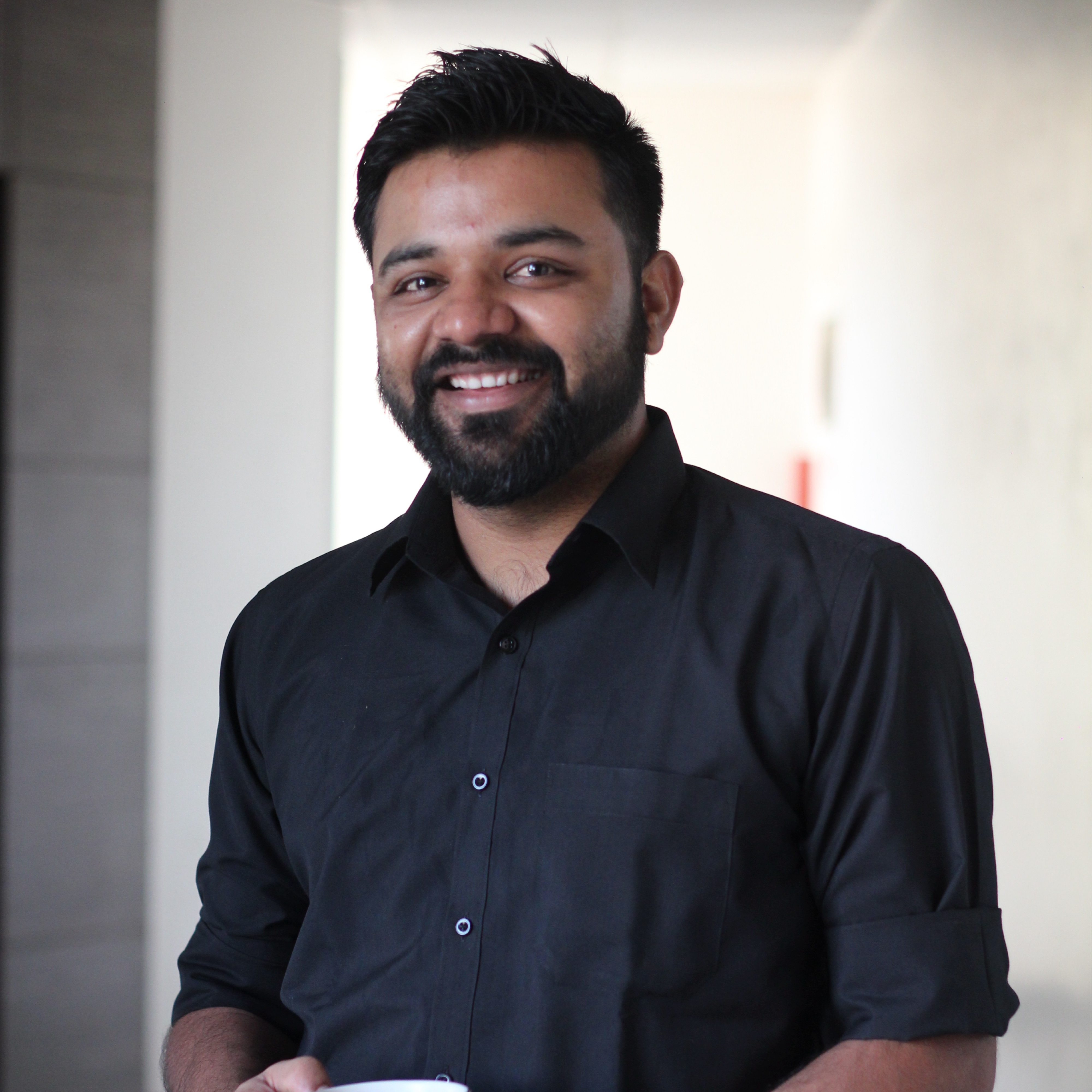 This is the image of Pranav in black formal shirt and smile on his face.