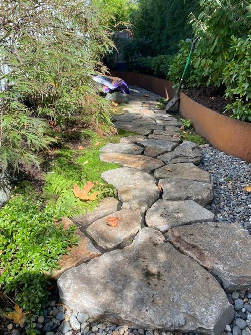A beautiful scene of landscape design by SAKAI Landscape and Design. Moss and stone paving that lead to the backyard