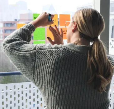 Woman placing post-it notes on her window in her home