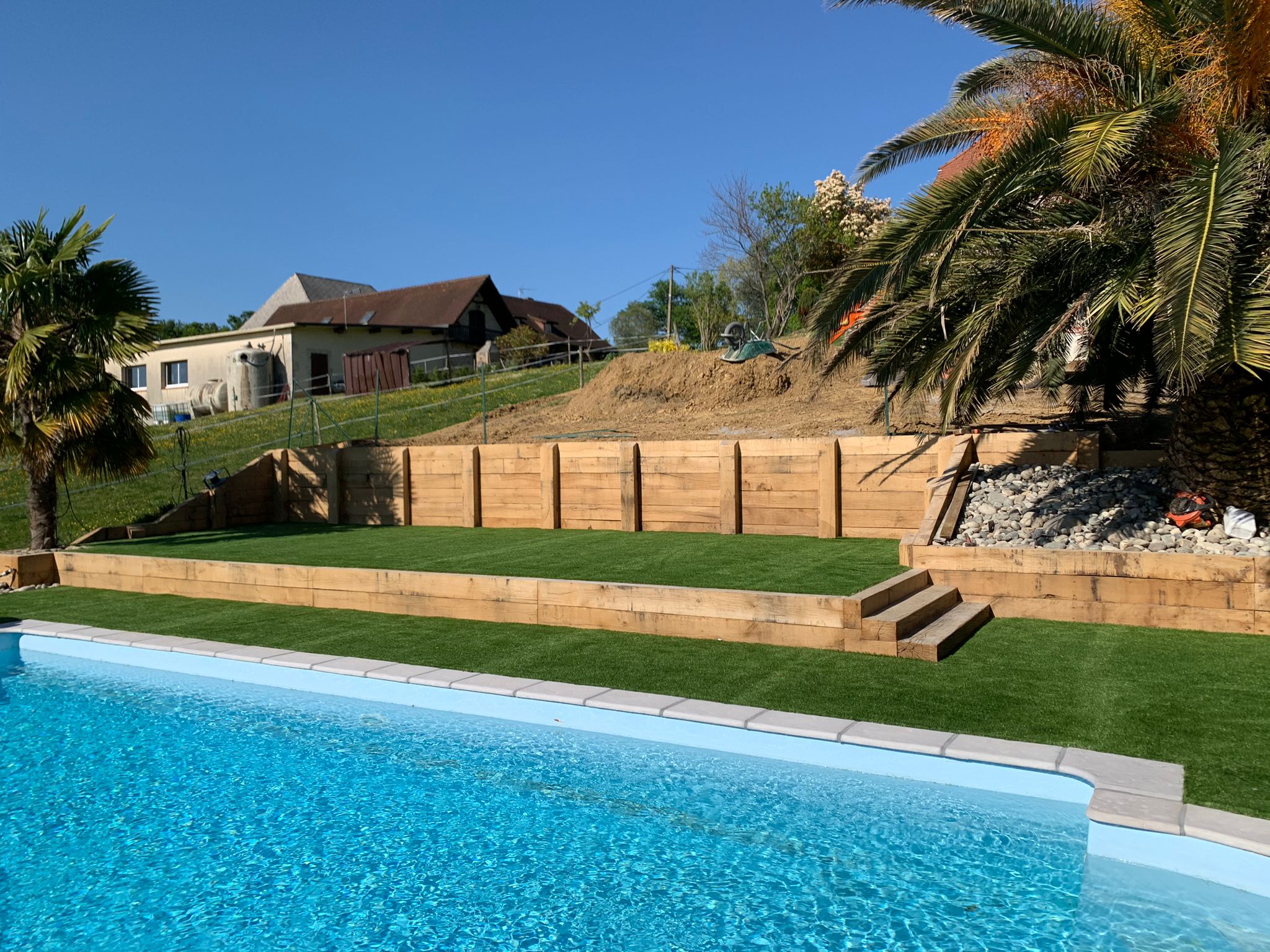 Terrasses en traverses de bois autour de la piscine