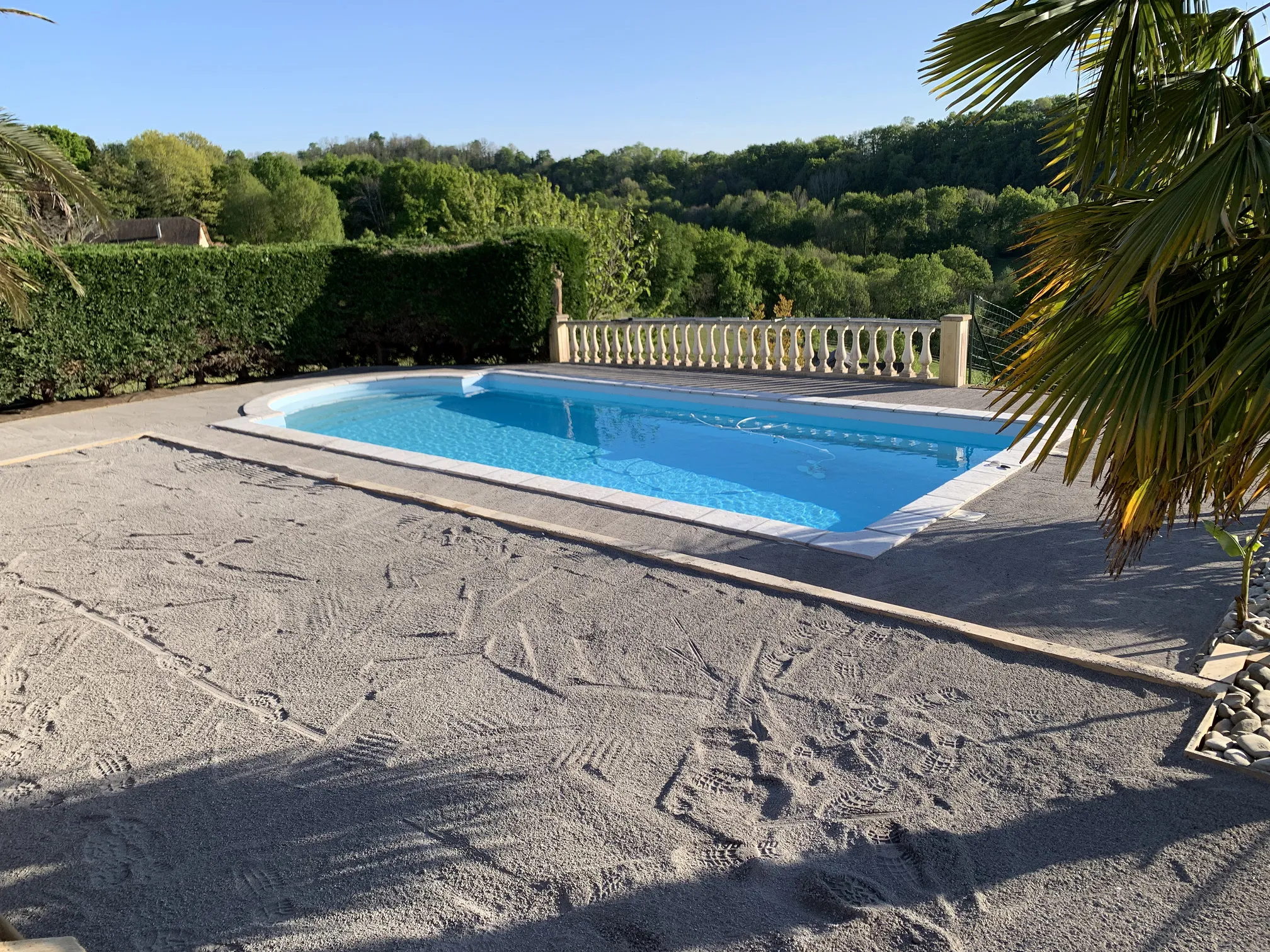 Plage de piscine en cours de préparation, sable compacté avant la pose du revêtement