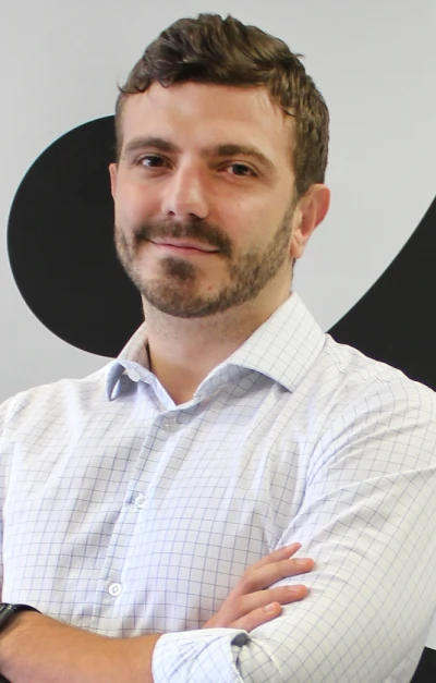Foto de Gabriel Barreto. Homem branco, cabelos e olhos castanhos claro, de barba e camisa social branca.