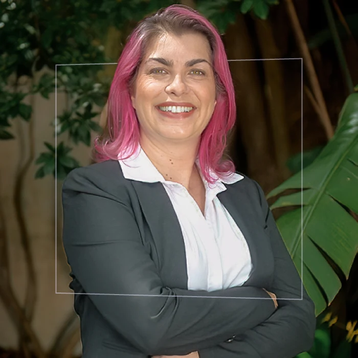 Helena Poças Leitão é Fundadora do Sua Escola Ideal. Mulher branca de cabelos rosas e olhos claros com terno cinza e camisa branca.