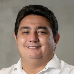 Foto de Danilo Yoneshige, CEO da Layers Education. Homem pardo, cabelos e olhos castanhos, de camisa polo branca.