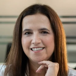 Claudia Zuppini Dalcorso, Elos Educacional. Mulher branca, de cabelos e olhos castanhos, com camisa branca. 