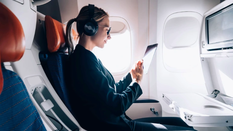Passenger stretching legs in airplane aisle to stay comfortable with hernia