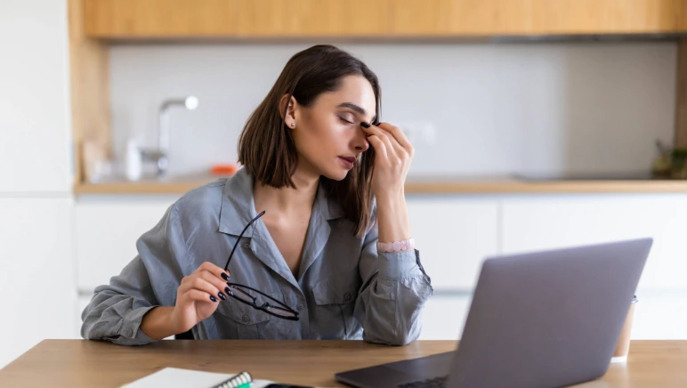 Stressed woman holding abdomen, symbolizing connection between stress and hernia discomfort