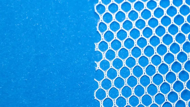 Image of a hernia mesh on top of blue background.