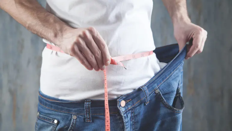 Patient looking concerned while checking weight on scale after surgery.