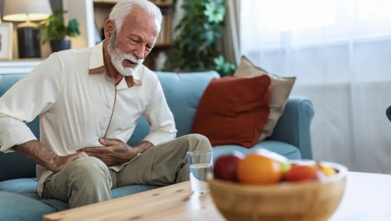 Man gently holding abdomen for hernia pain relief.