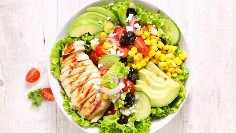 Fresh bowl of salad with lean grilled chicken — ideal hernia recovery meal.