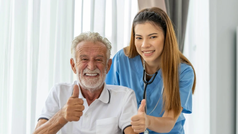 Happy patient being assisted out of the hospital by a nurse.