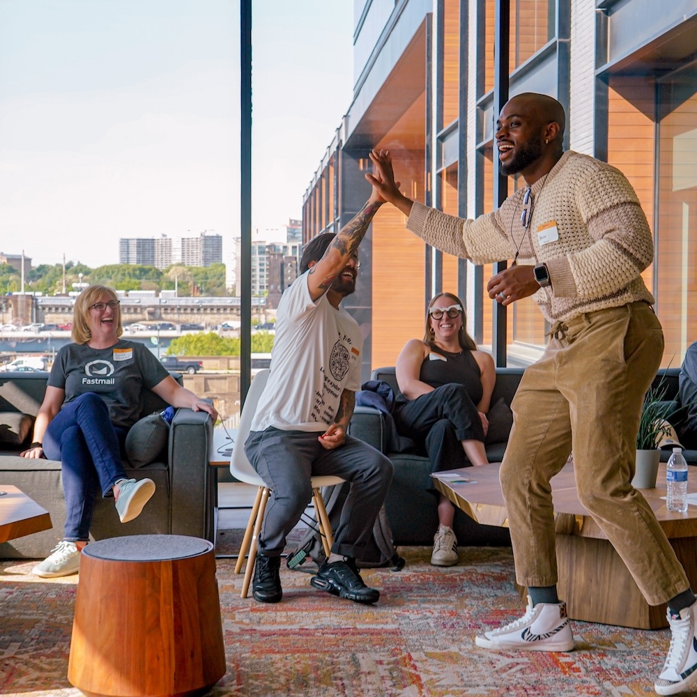 four people standing around laptop