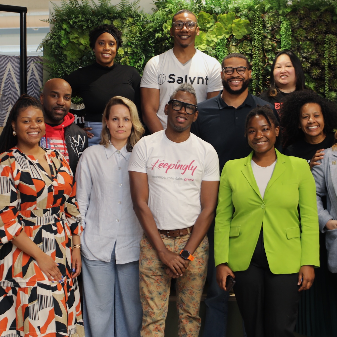four people standing around laptop