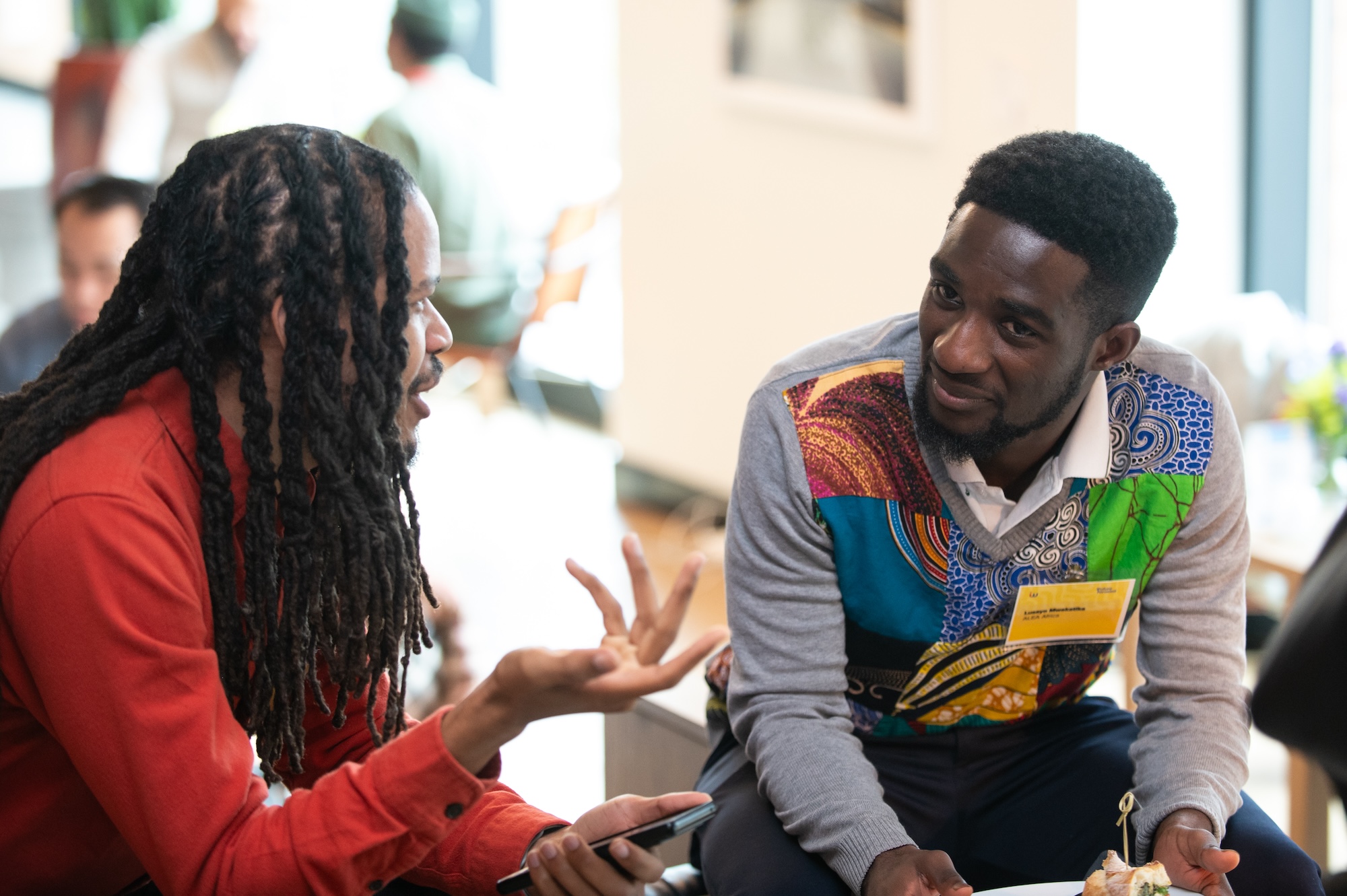 Woman on laptop smiling in audience of talk