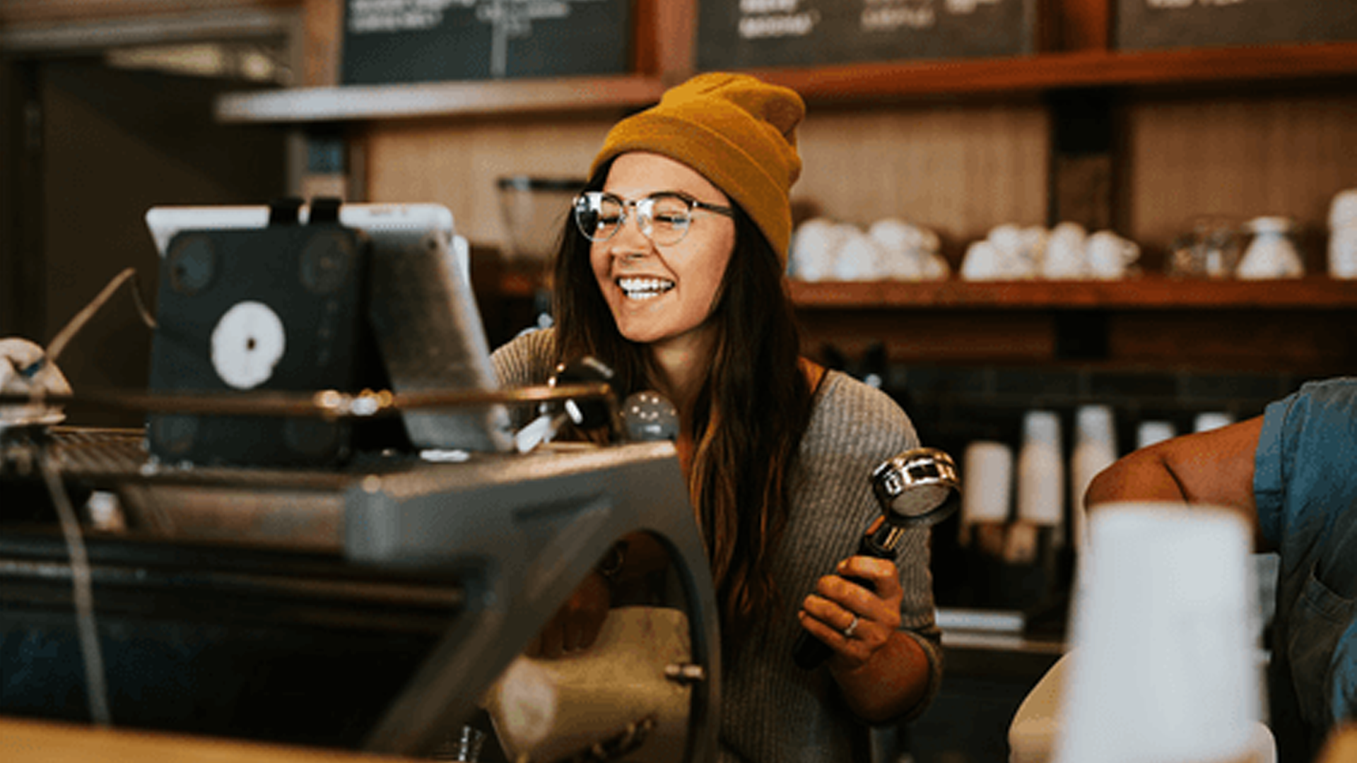 A smiling woman working at a cafe. As local businesses are striving to recover back from the post-pandemic fall, so is she.