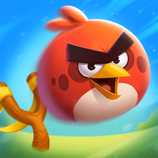 Red Angry Bird character with black eyebrows flying above a green field next to a wooden slingshot.