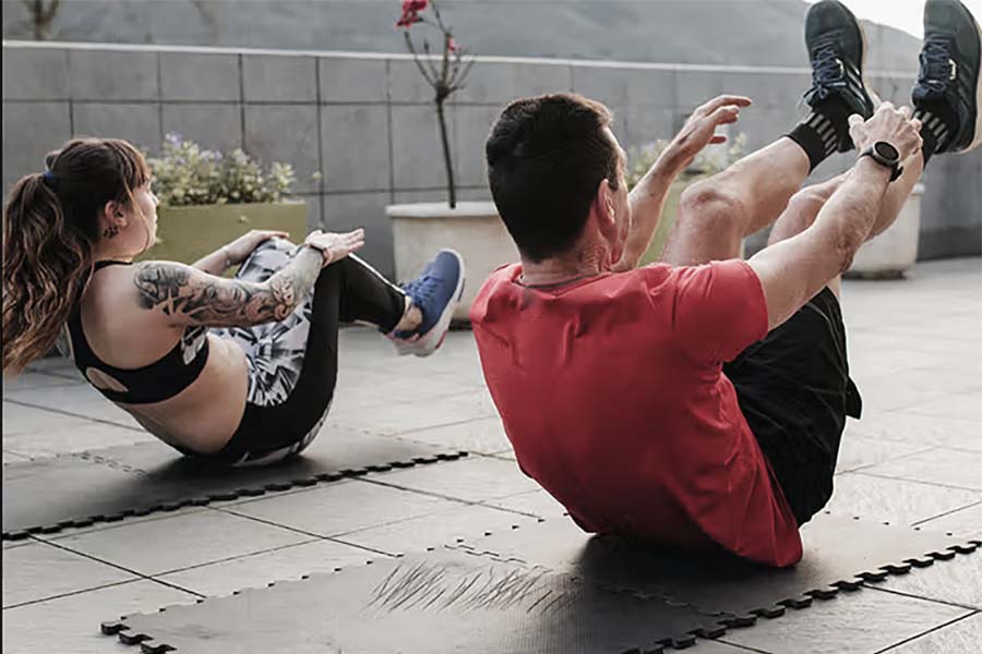a woman and a man doing ab exercises