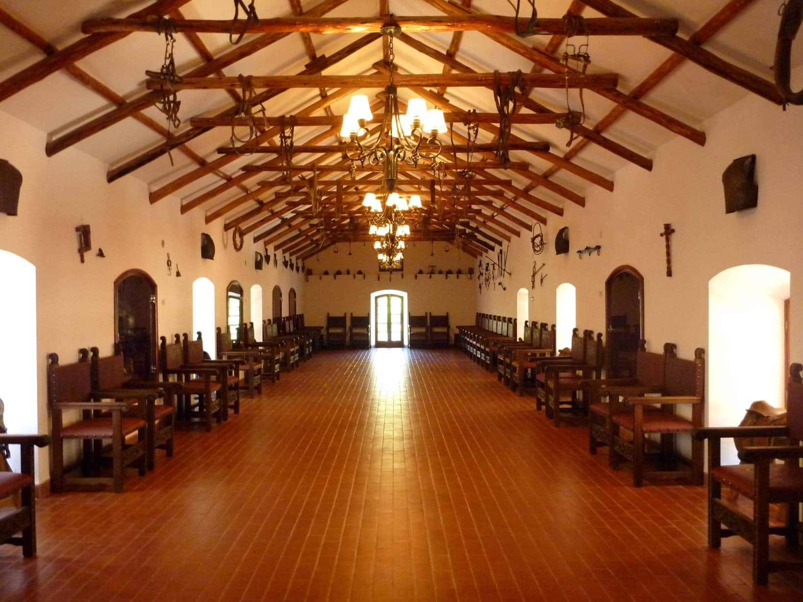 Salón de la hacienda con techo pintado y mobiliario colonial