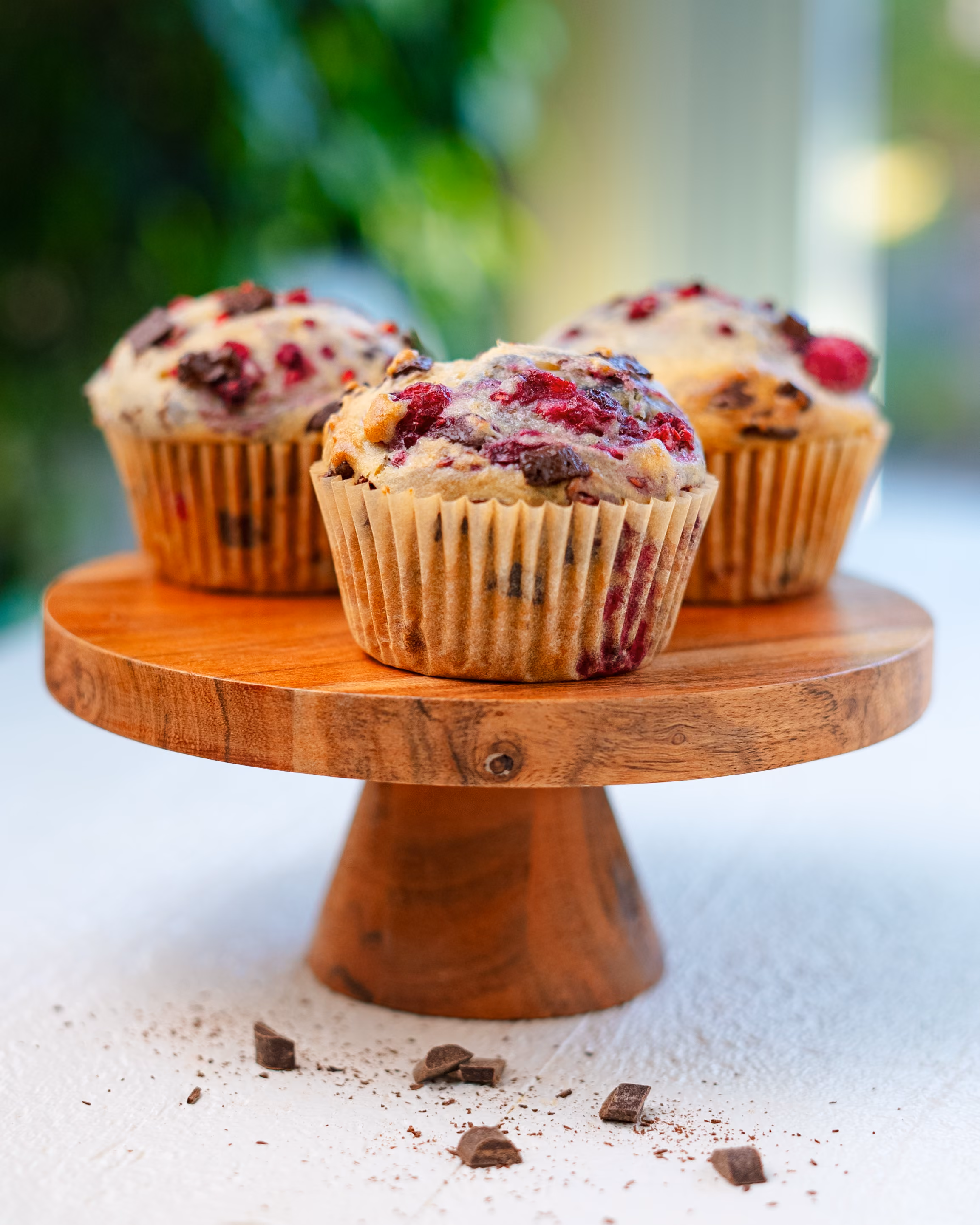 Vegan raspberry chocolate chip muffins on a wire rack