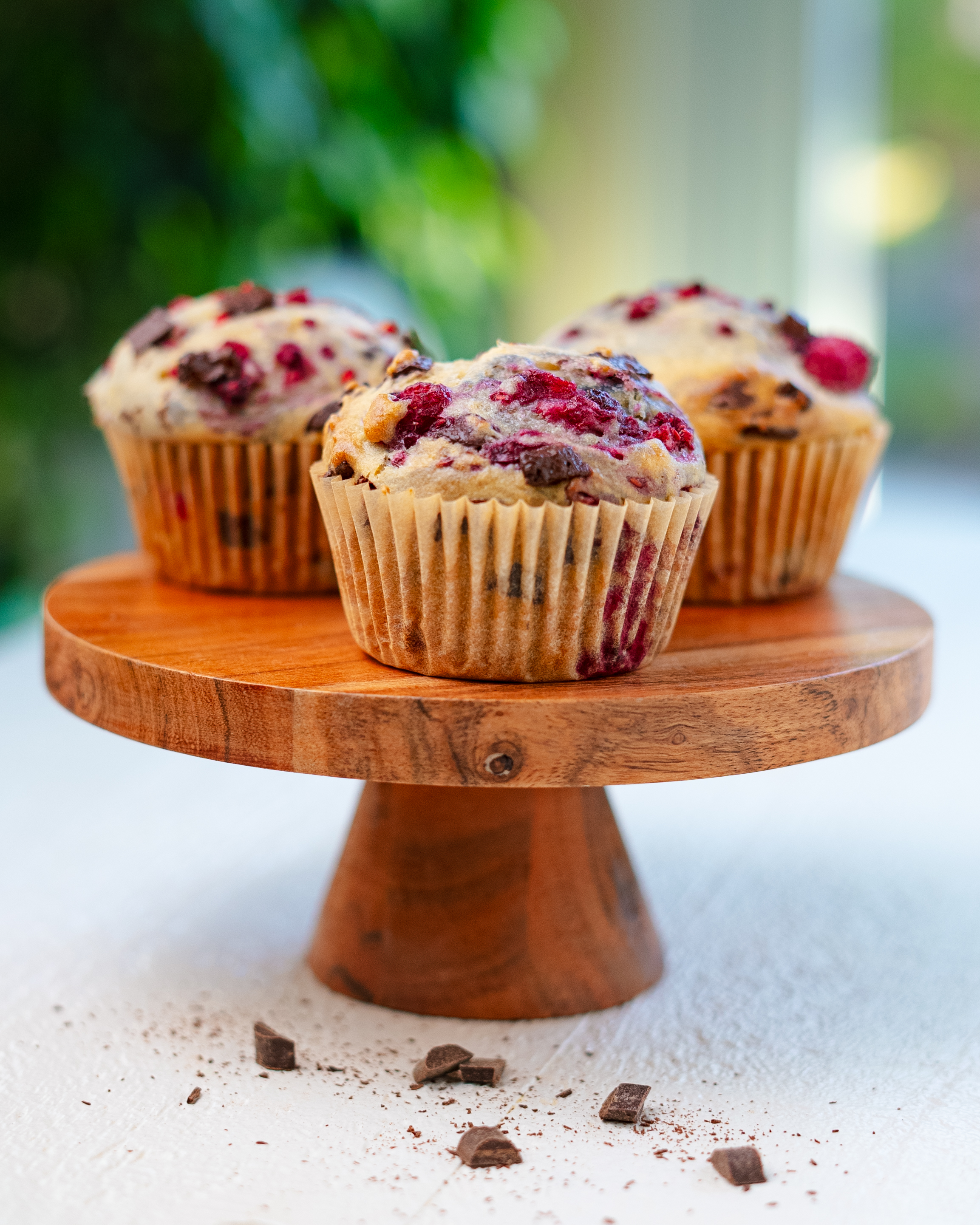 Vegan raspberry chocolate chip muffins on a wire rack
