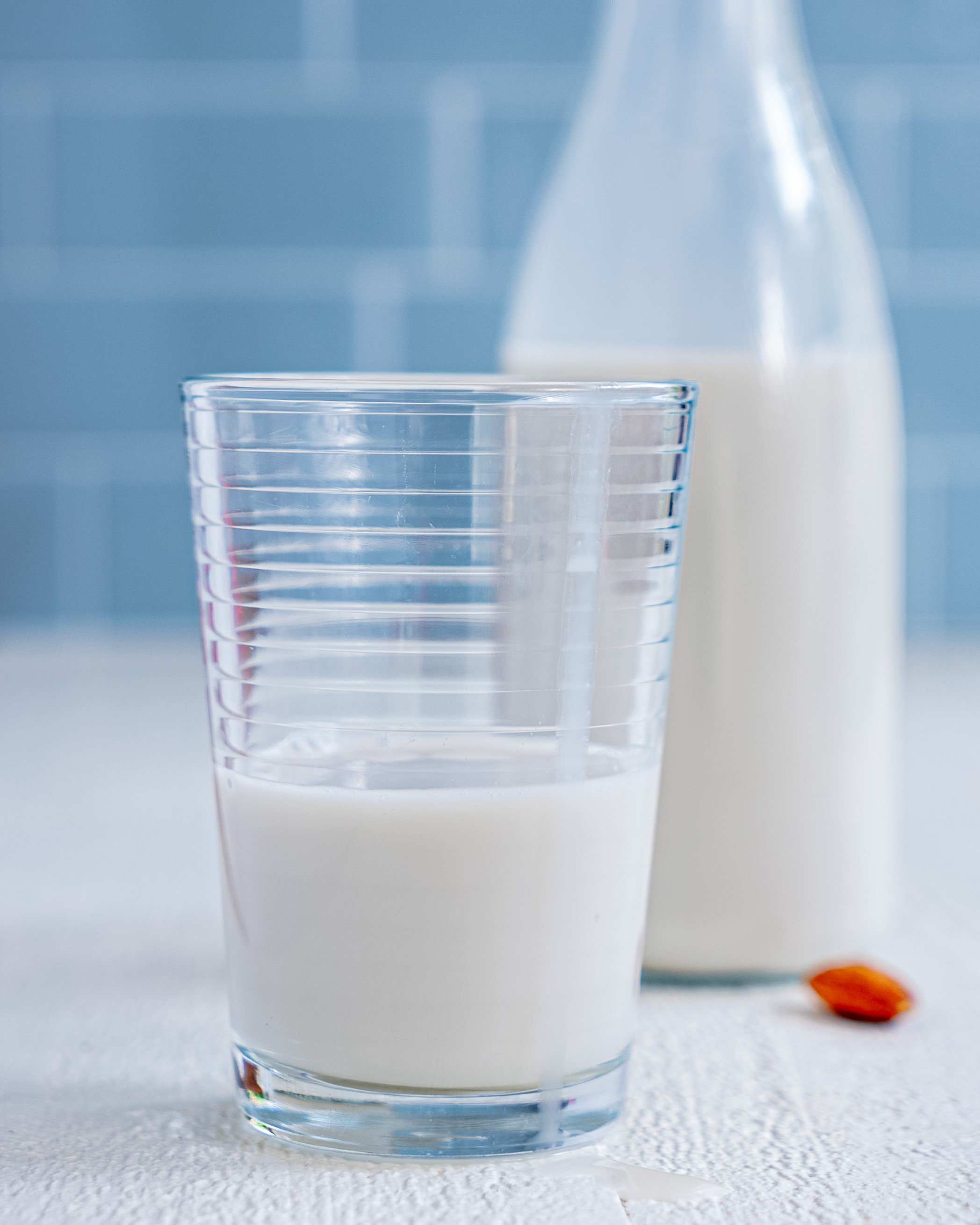 Close-up of creamy homemade almond milk being poured from a glass bottle