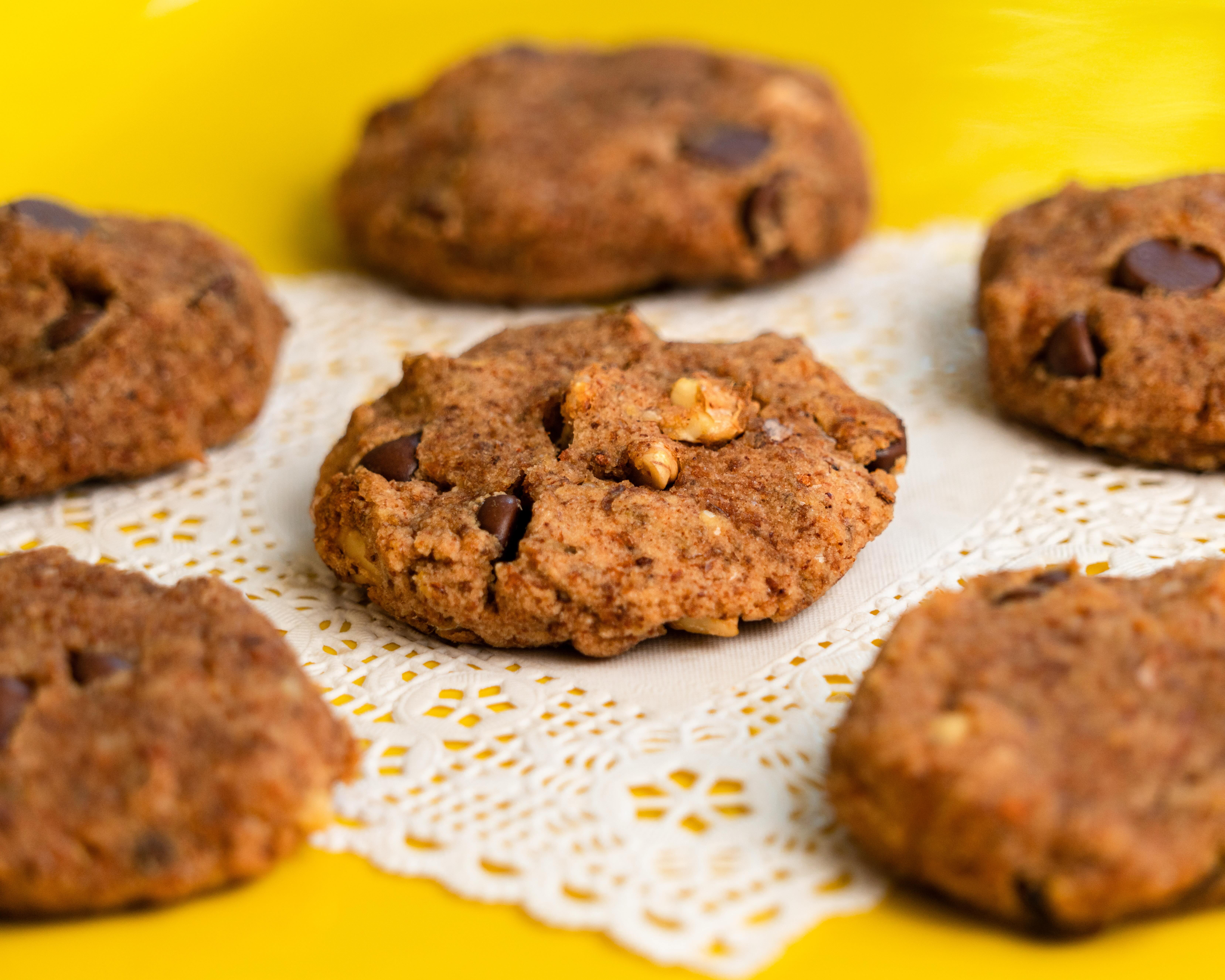Gluten-free vegan almond pulp cookies with chocolate chips on a parchment-lined baking sheet