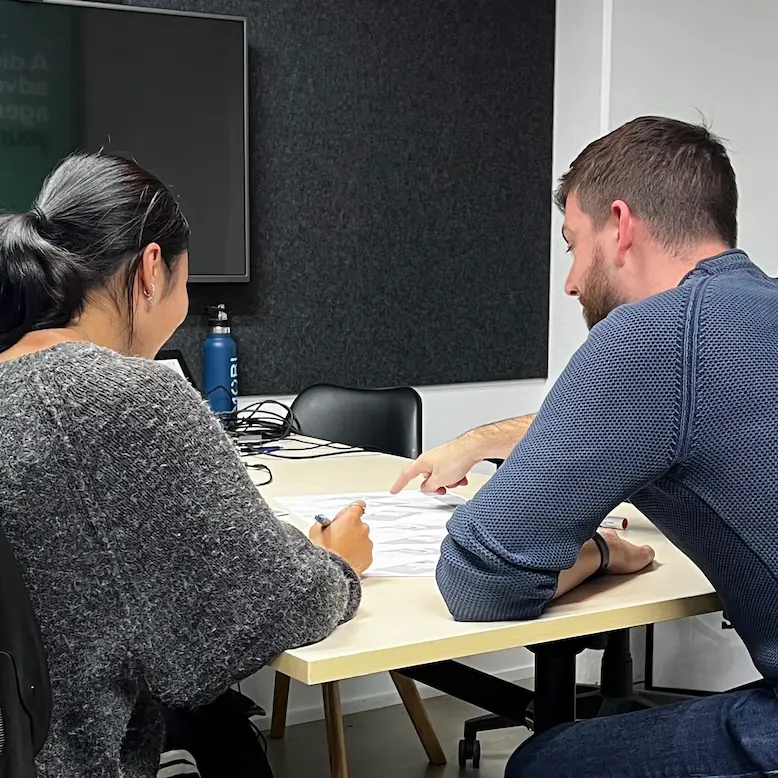 Modal Architecture residential design consultation reviewing architectural plans with a client