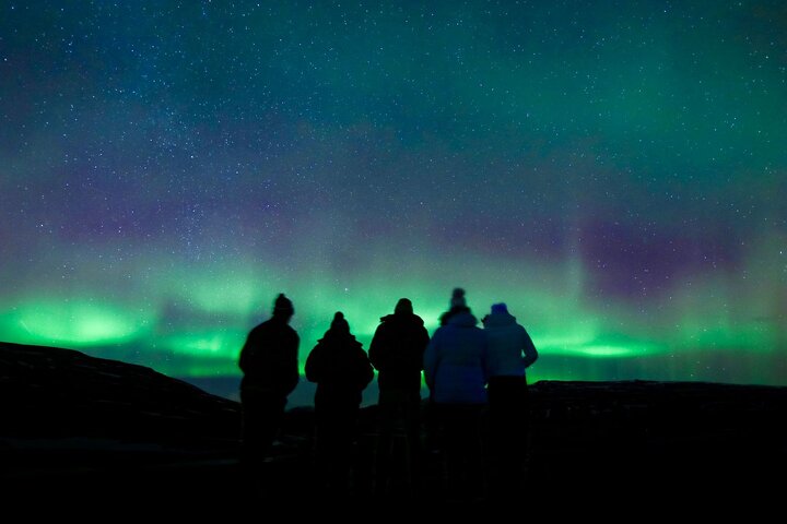 Small group Northern Lights tour guests watching aurora borealis