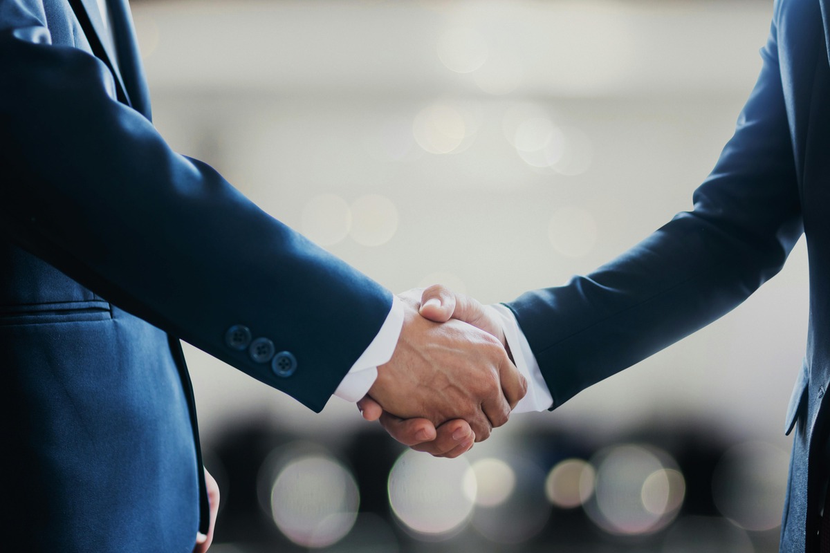 A financial advisor and a lead aggregator shaking hands