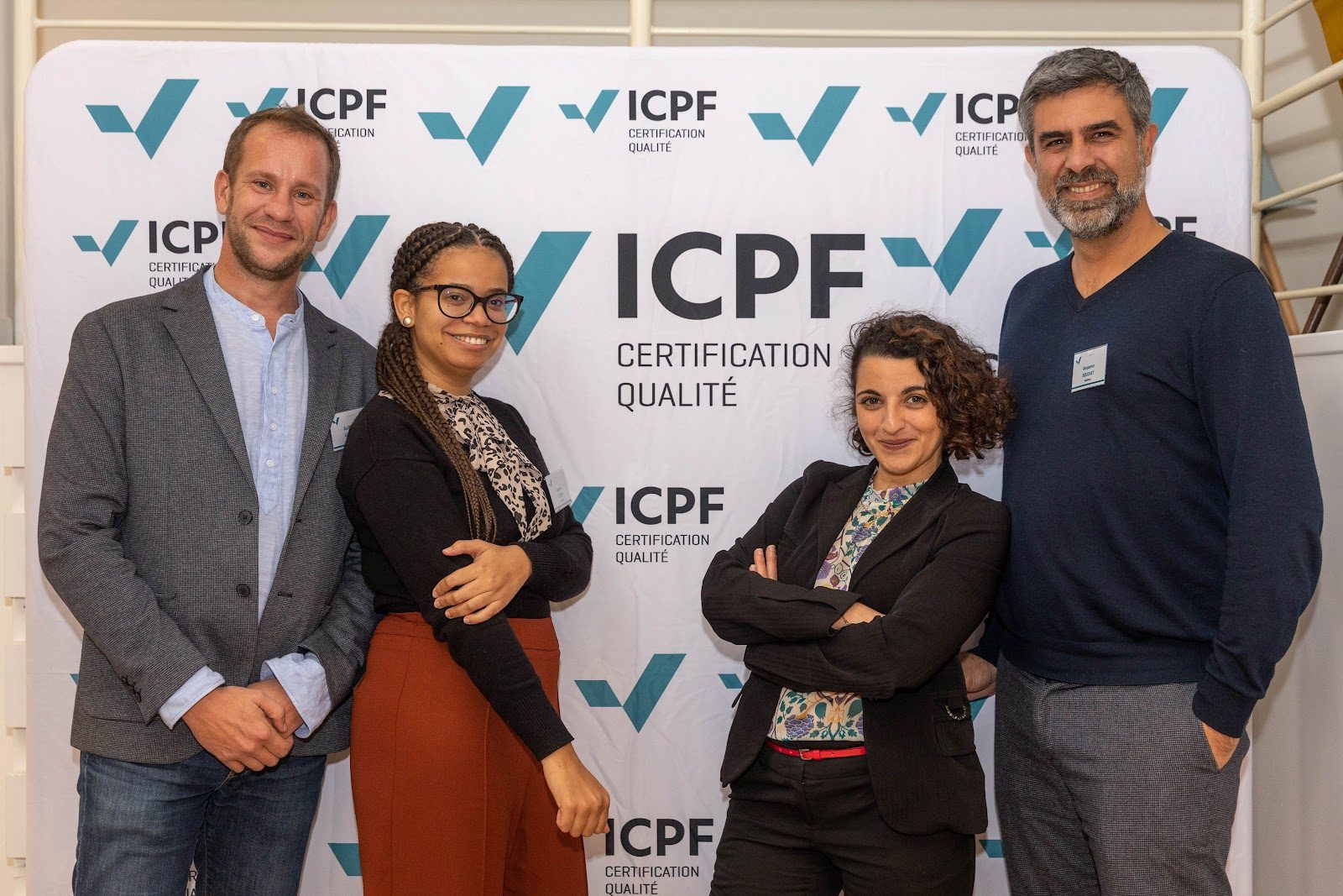 Équipe ICPF devant le mur de logos de l'organisme certificateur, illustrant l'usage du logo et du certificat ISO 9001
