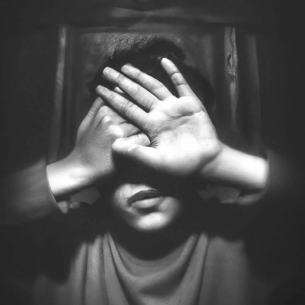 a person covering their eyes with their hands