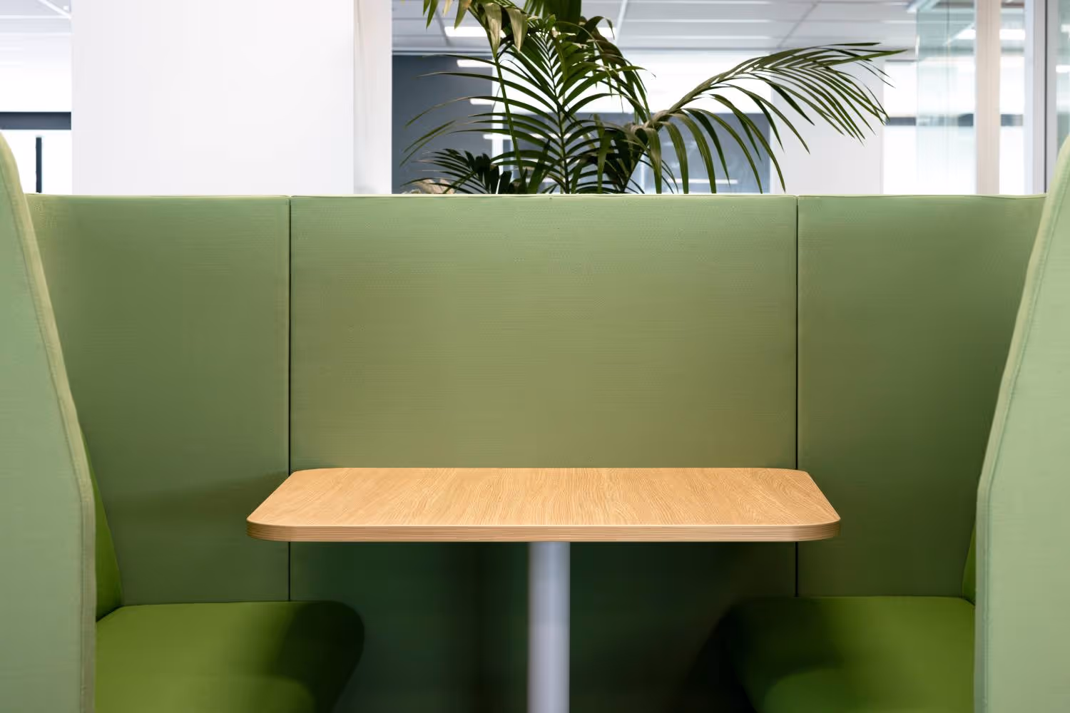 green soft seating with wood table